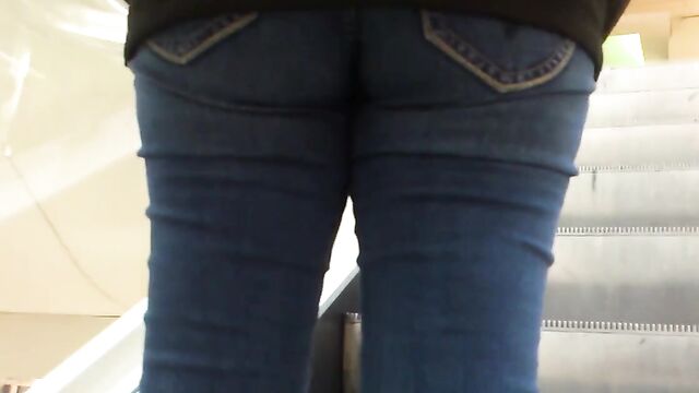 Молоденькая девушка в обтягивающих штанах гуляет по торговому центру