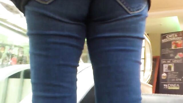 Молоденькая девушка в обтягивающих штанах гуляет по торговому центру