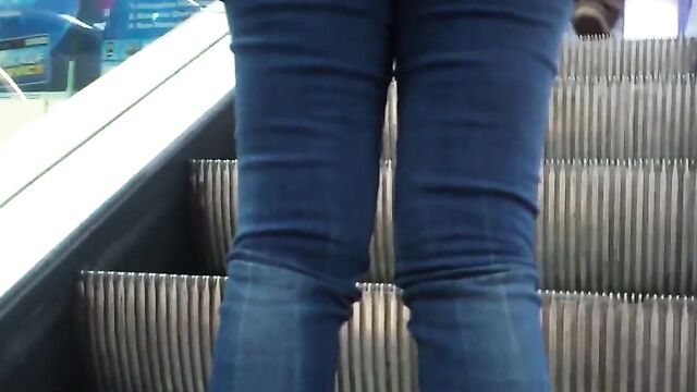 Молоденькая девушка в обтягивающих штанах гуляет по торговому центру