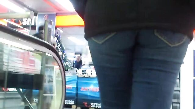 Молоденькая девушка в обтягивающих штанах гуляет по торговому центру