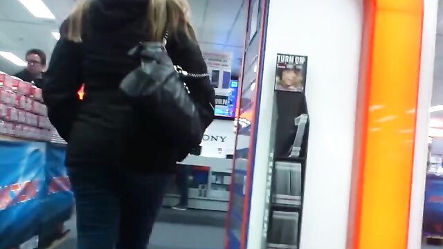 Молоденькая девушка в обтягивающих штанах гуляет по торговому центру