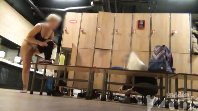 Голая женщина с широким тазом гуляет по раздевалке без трусиков