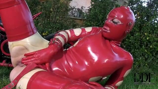 Баба в латексе мастурбирует пизденку пальцами на газоне