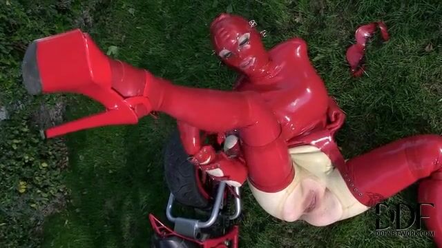 Баба в латексе мастурбирует пизденку пальцами на газоне