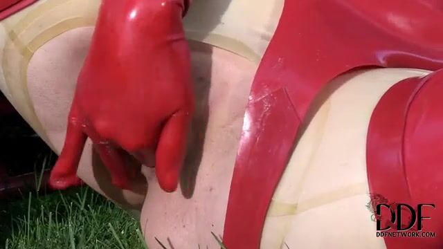 Баба в латексе мастурбирует пизденку пальцами на газоне