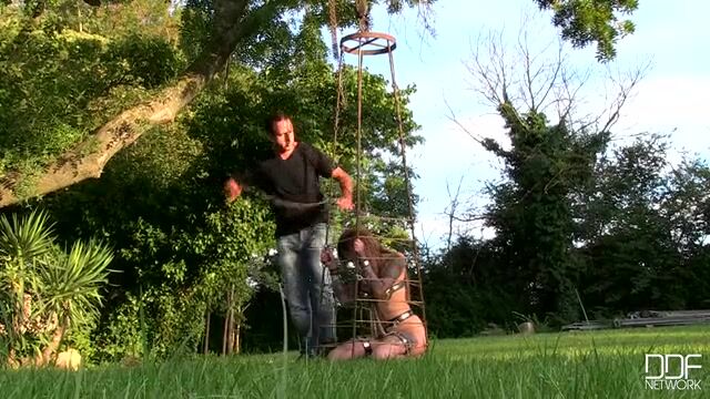 Татуированная рабыня в металлической клетке сильно возбуждает хозяина