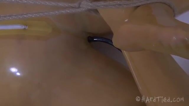 Рабыня в латексном костюме извивается перед хозяином в ванной